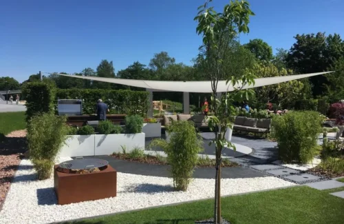 Sonnensegel über einem Garten mit Sitzgelegenheiten