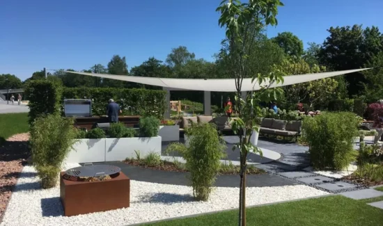 Sonnensegel über einem Garten mit Sitzgelegenheiten
