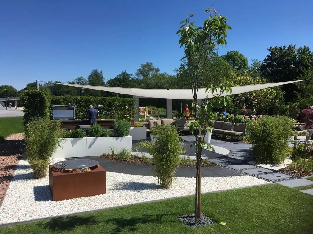 Sonnensegel über einem Garten mit Sitzgelegenheiten
