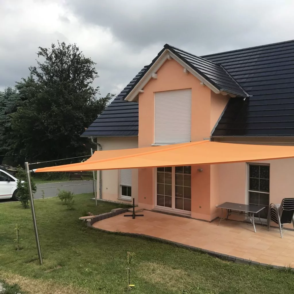 Oranges Sonnensegel über einer Terrasse bei einem Privathaus