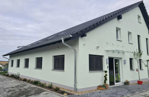 Außenansicht eines Neubaus, grüne Fassade