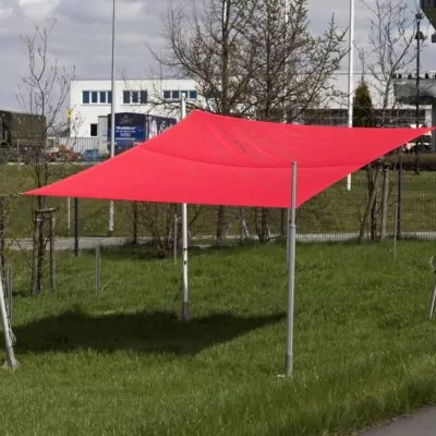 rotes Sonnensegel über einer Wiese