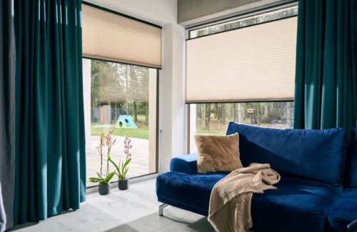 Modernes Wohnzimmer mit blauen Sofa und großen Fenstern